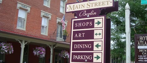 A signpost with directions to shops, art, dining, and parking on Main Street.