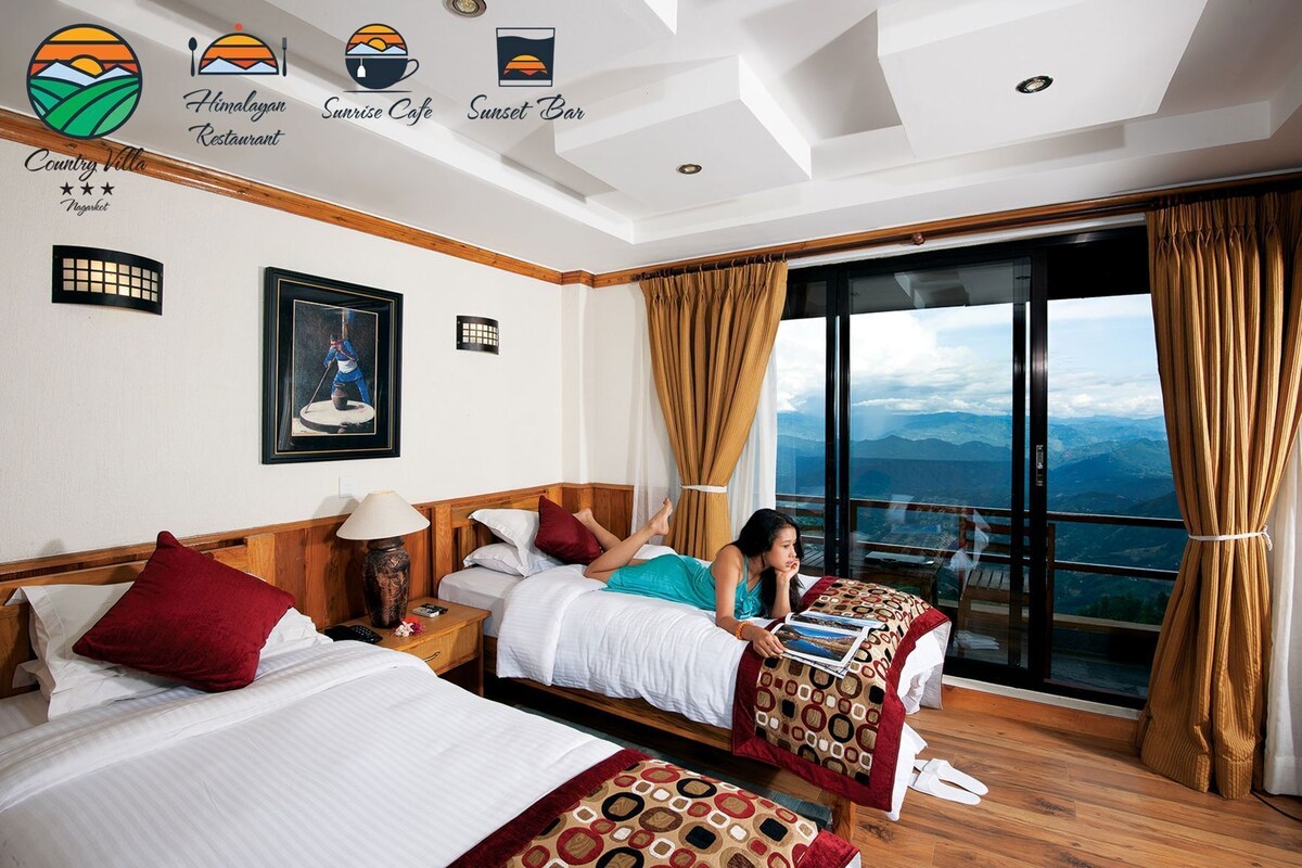 Una habitación de hotel con dos camas, un ventanal con vistas a la montaña y un balcón.