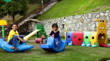 Kids can play on the slide, climbing frame, and train set in this outdoor play area.