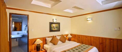 A bedroom with a bed, nightstands, a mirror, a painting, and a wooden ceiling.