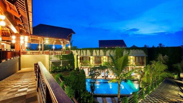A resort with a swimming pool, a covered outdoor area, and a building with multiple windows. - Ubud Wana Resort (Ubud)