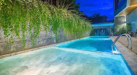 室外游泳池和瀑布游泳池,提供日光浴躺椅