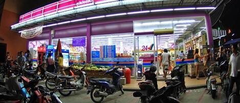 A brightly lit 24-hour convenience store with a variety of products on display.