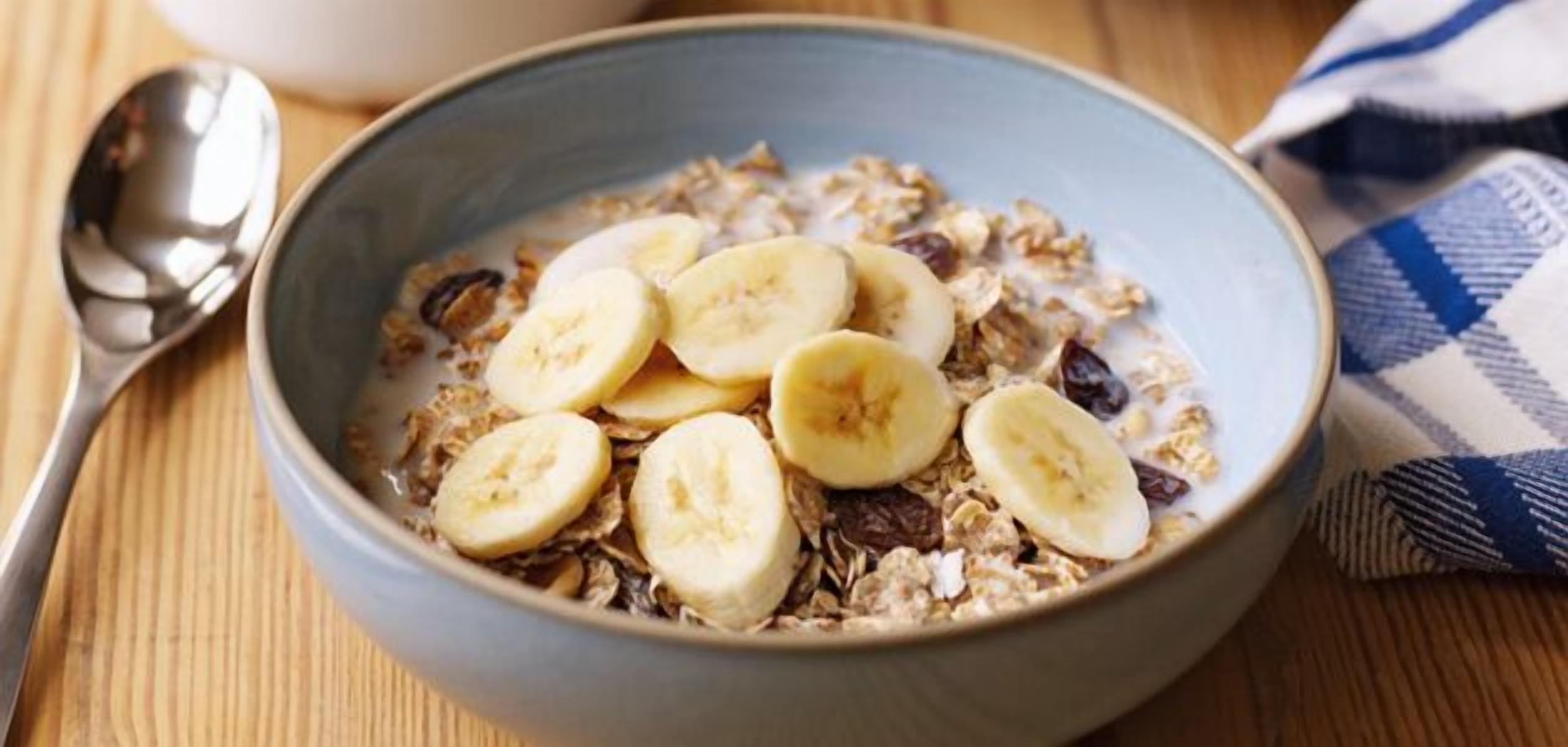 Eine Schüssel Müsli mit Bananenscheiben und Rosinen.