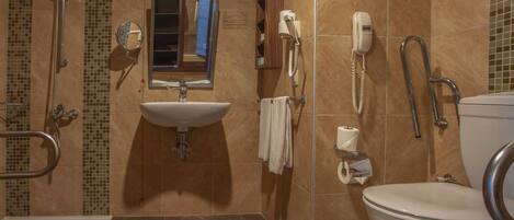 A bathroom with a sink, mirror, toilet, and shower.