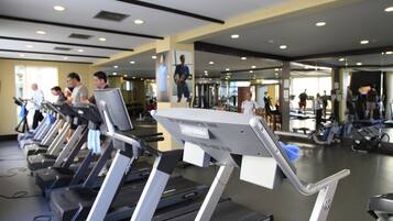 Un gimnasio con cintas de correr y equipo de ejercicio.