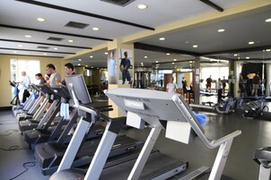 Un gimnasio con cintas de correr y equipo de ejercicio.