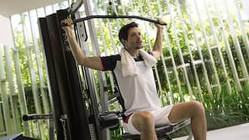 A person using a gym machine with a window in the background.