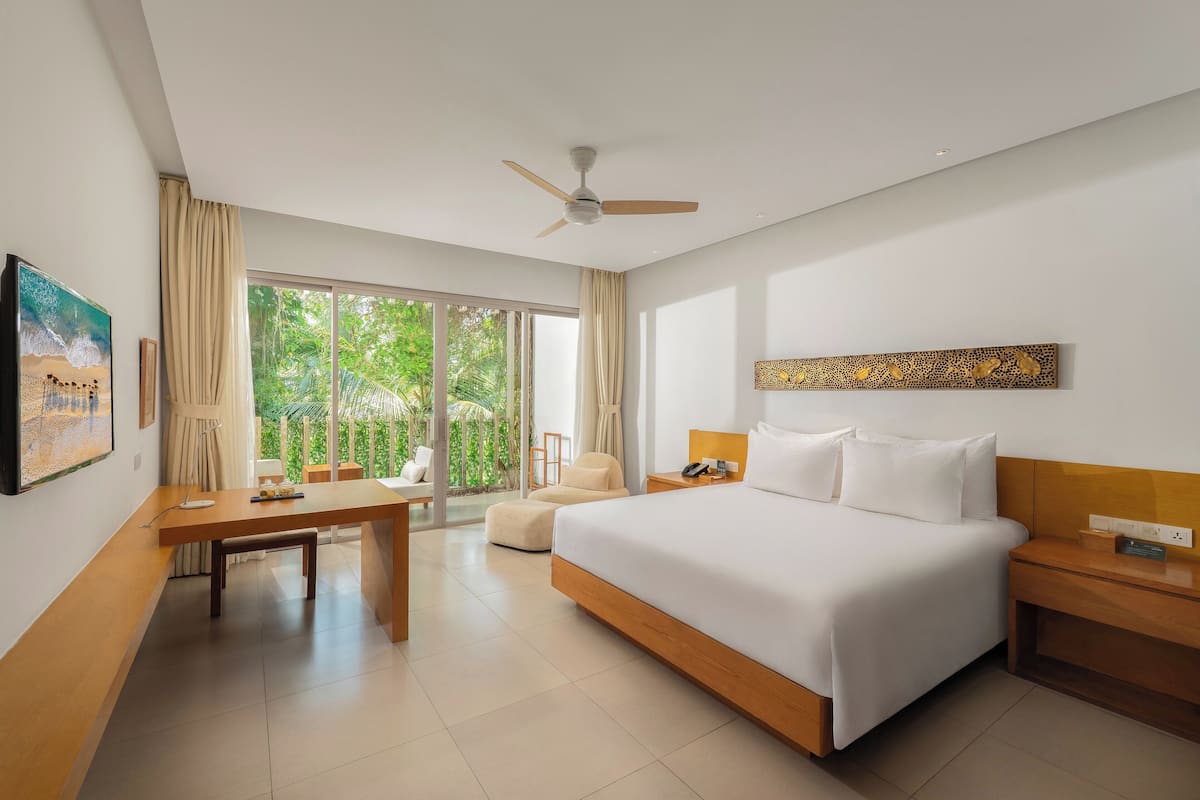 Une chambre d’hôtel moderne, dotée d’un grand lit, d’un bureau et d’une chaise.