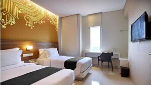 A hotel room with two beds, a desk, a chair, a TV, and a window. - The Life Hotels (Surabaya)