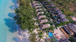 An aerial view of a resort with thatched-roof cottages, a swimming pool, and a beach. - Tinkerbell Resort (Ko Kood)