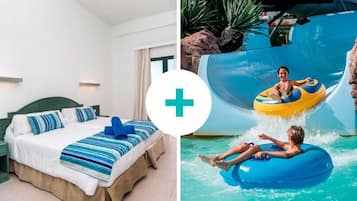 Quarto de hotel com cama, mesa de cabeceira e janela.