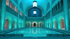 Una piscina interior amplia con techos abovedados y un pasillo central.