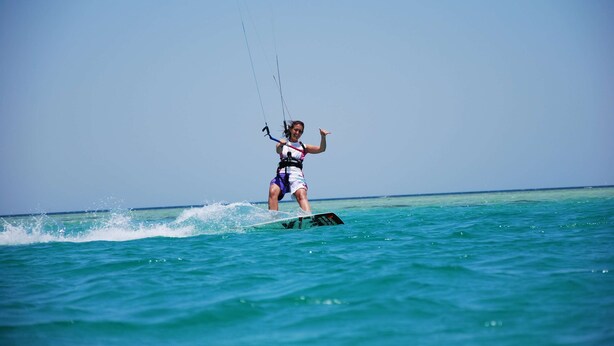 Una persona practica windsurf en un día despejado.