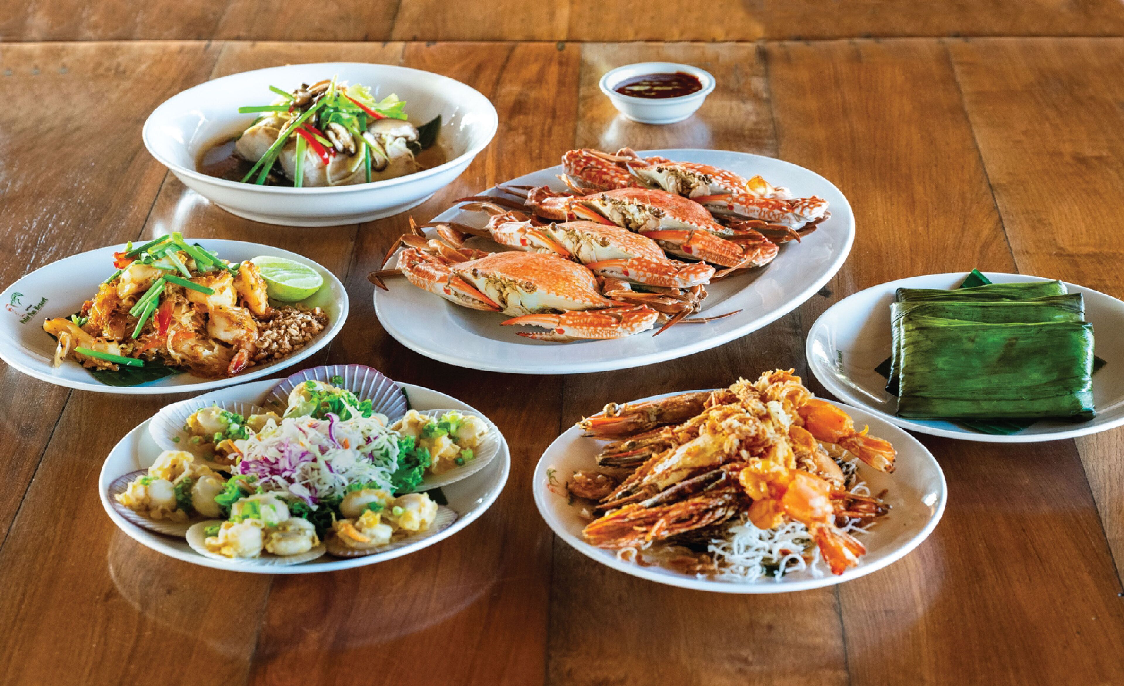 A variety of seafood dishes on a wooden table.