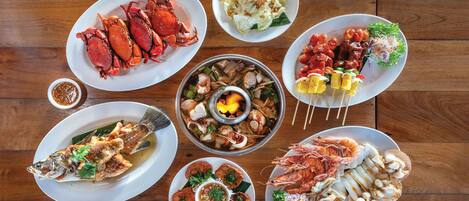 A variety of seafood dishes arranged on a wooden table.