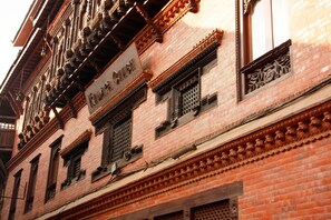 Un edificio tradicional con elaboradas esculturas de madera y un letrero que dice 'Kumari Chowk'.