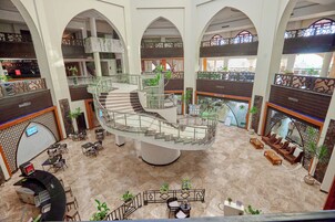 A multi-level atrium with a central spiral staircase, seating areas, and a bar.
