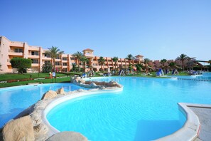 A resort with a large swimming pool, palm trees, and a multi-story building with balconies. - Jasmine Palace Resort & Spa (Hurghada)