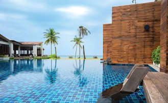 Una piscina al aire libre, sillones reclinables de piscina