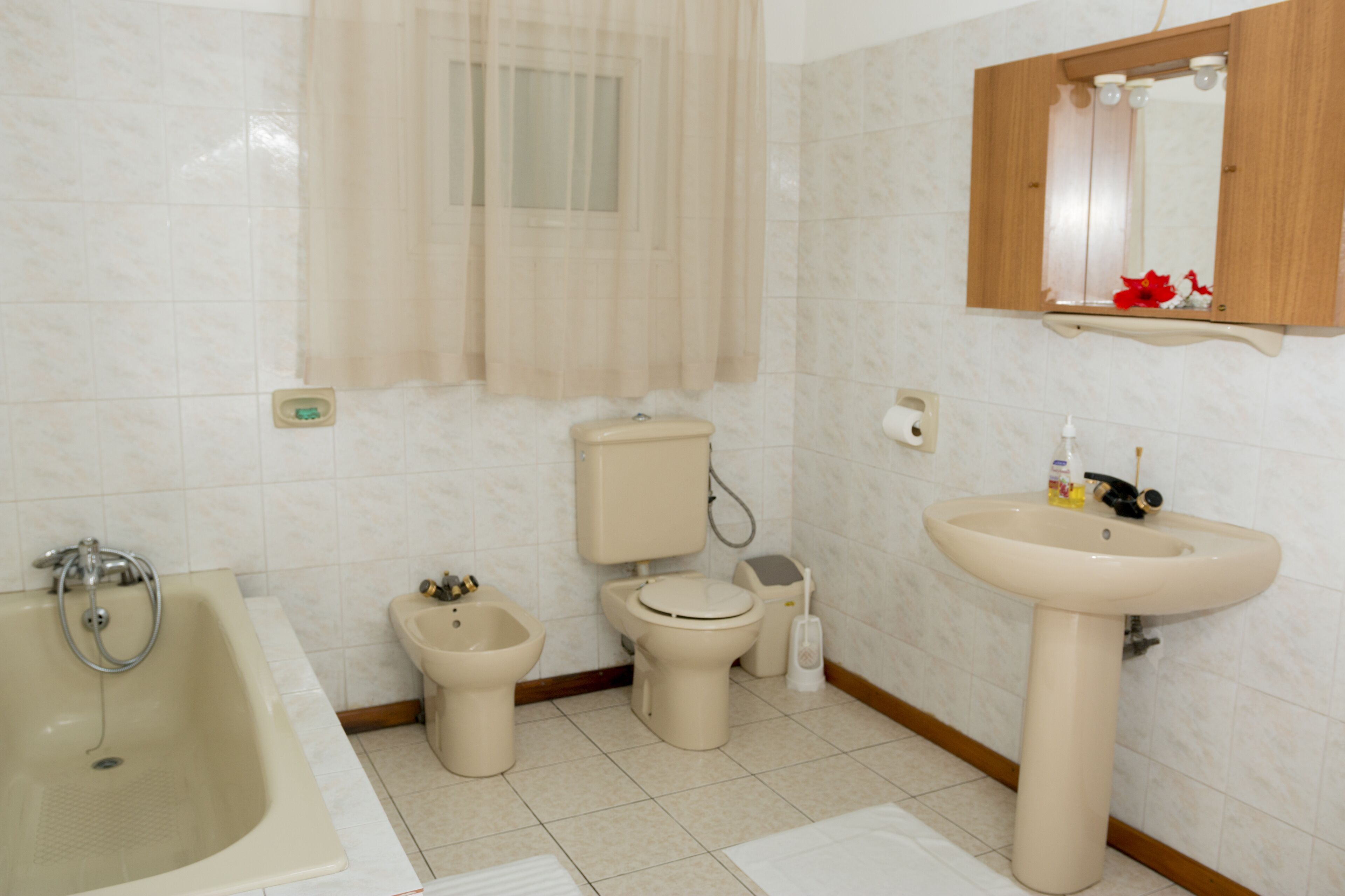 A bathroom with a bathtub, toilet, bidet, and sink.