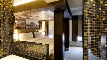 Een moderne hotelkamer met een groot bed, een badkamer met een bad en muren versierd met mozaïektegels.