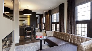 A modern living room with a sofa, a dining table, and a kitchen area in the background. - 't Goude Hooft (The Hague)