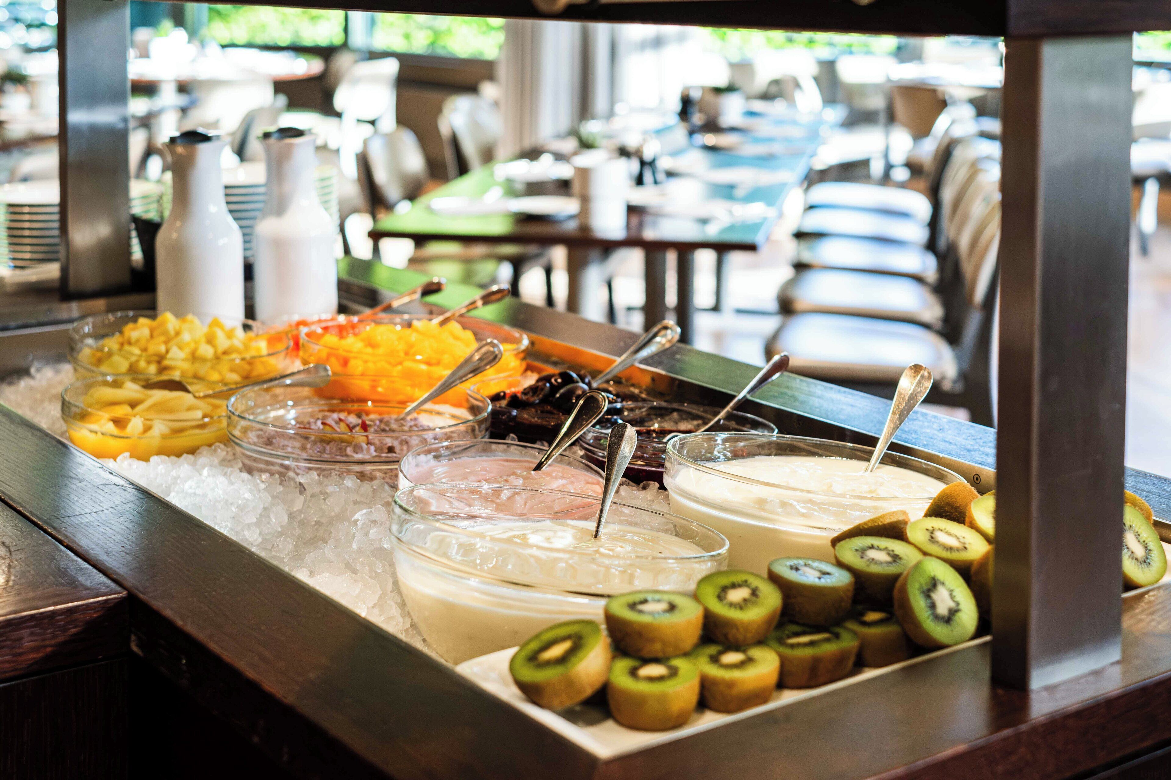 A buffet with various food items and beverages on a table.
