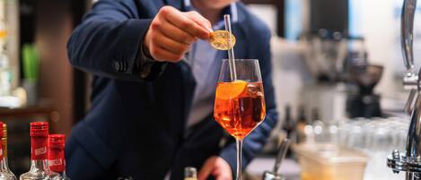 A bartender preparing a cocktail with a citrus garnish.