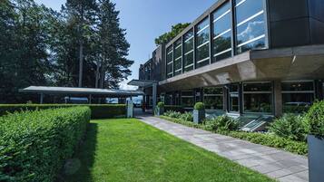 Un bâtiment moderne doté de grandes fenêtres, d’une allée couverte et d’un aménagement paysager bien entretenu.