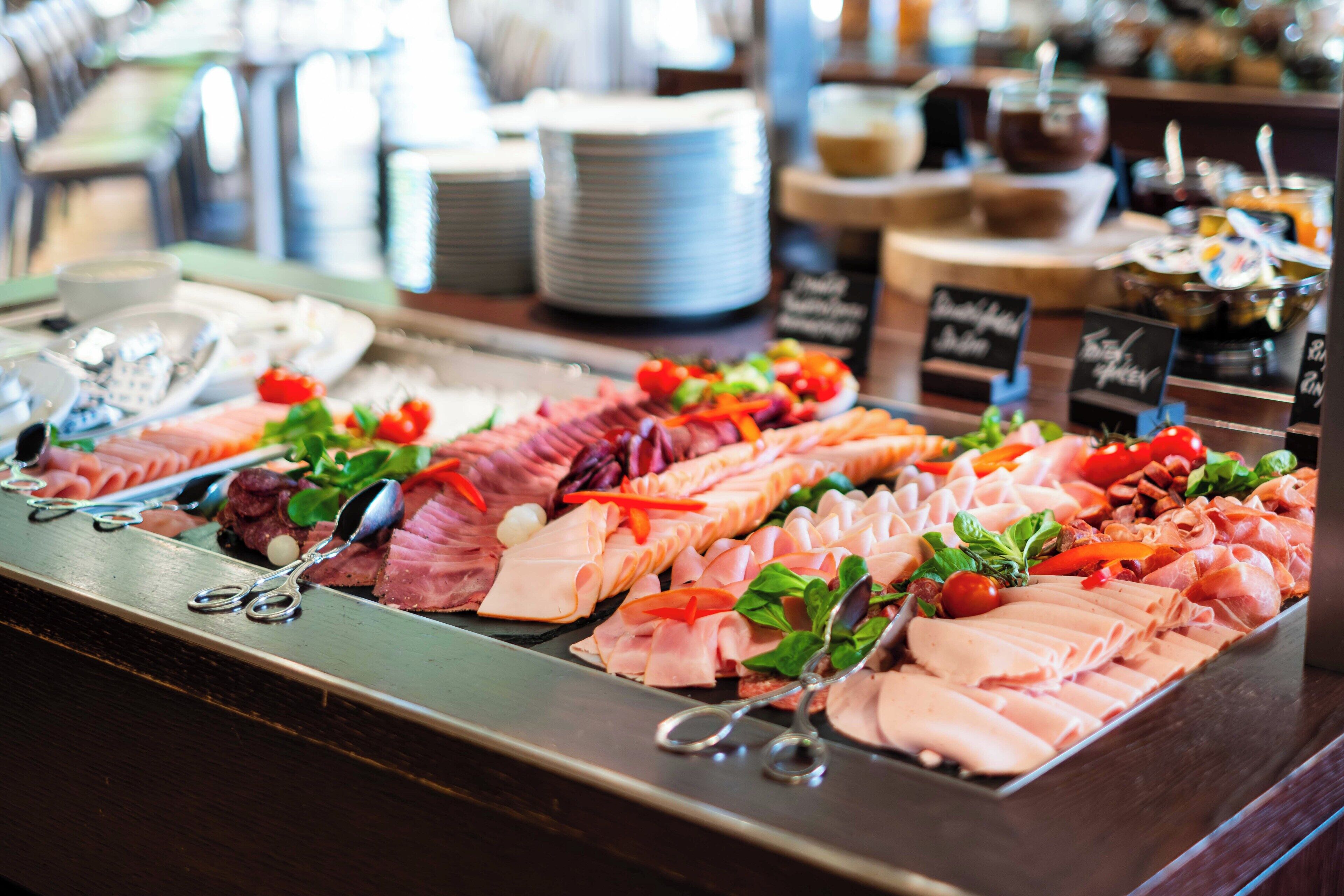 A buffet with various meats and vegetables.