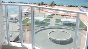 A balcony with a view of a beach and a roundabout. - Madison Hotel Nahariya (Nahariya)