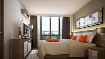 Una habitación de hotel moderna con una cama grande, un escritorio, un televisor de pantalla plana y un ventanal con vista a la ciudad.
