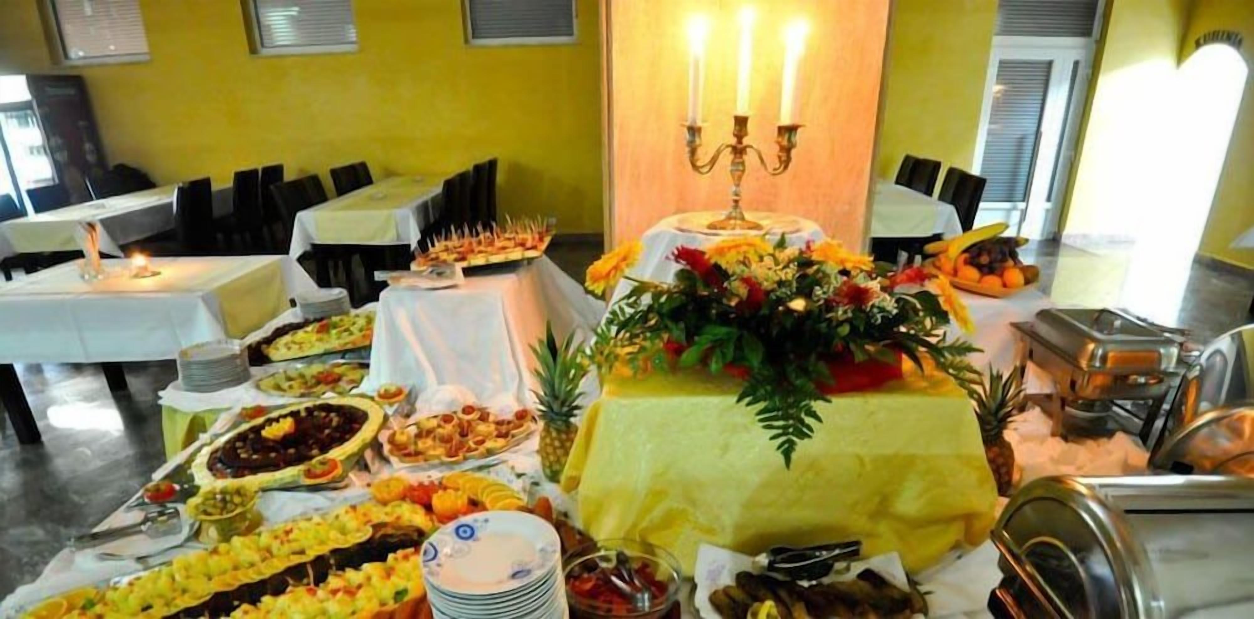 Un buffet con diversi piatti e un centrotavola floreale.