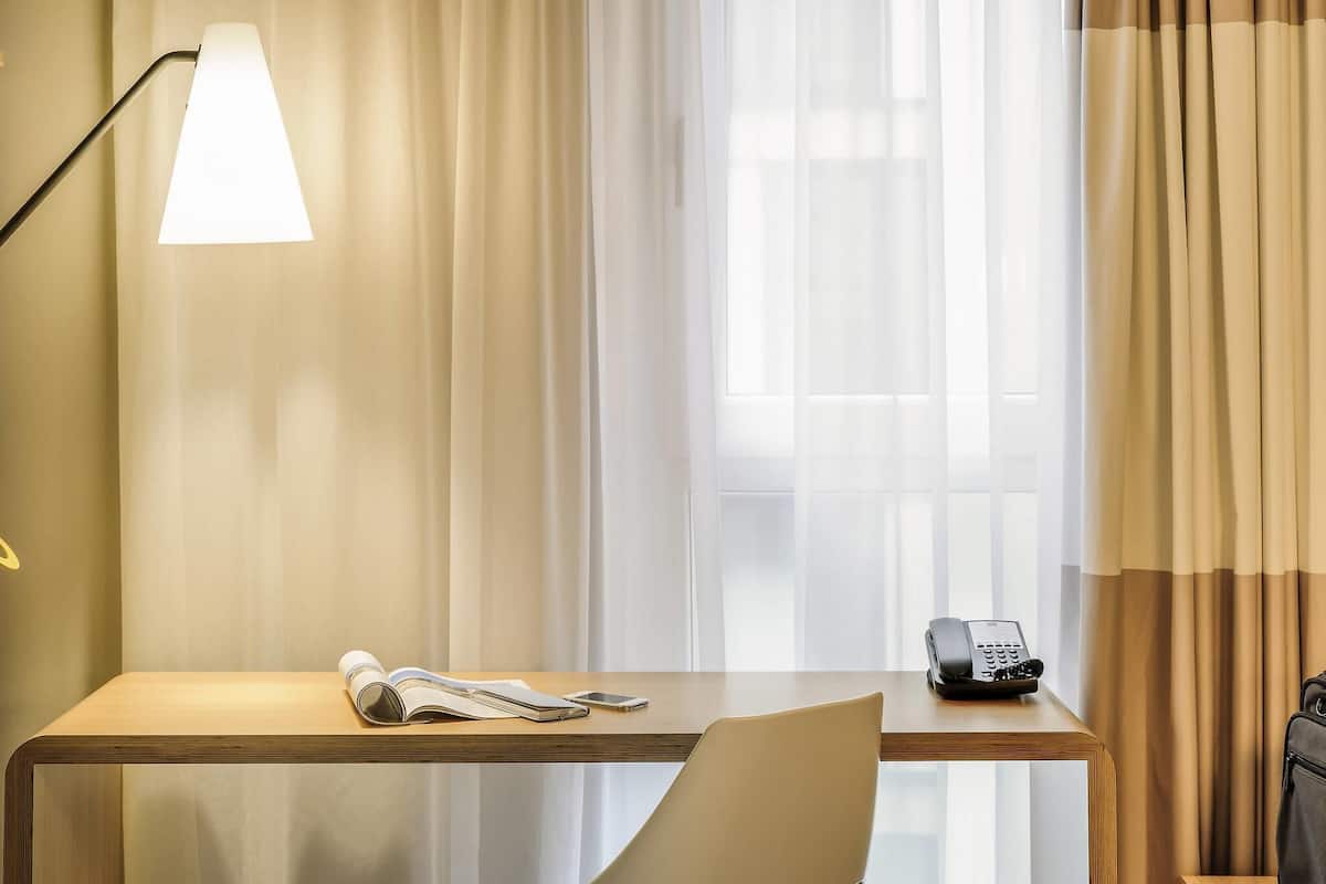 Hypo-allergenic bedding, desk, laptop workspace, blackout drapes
