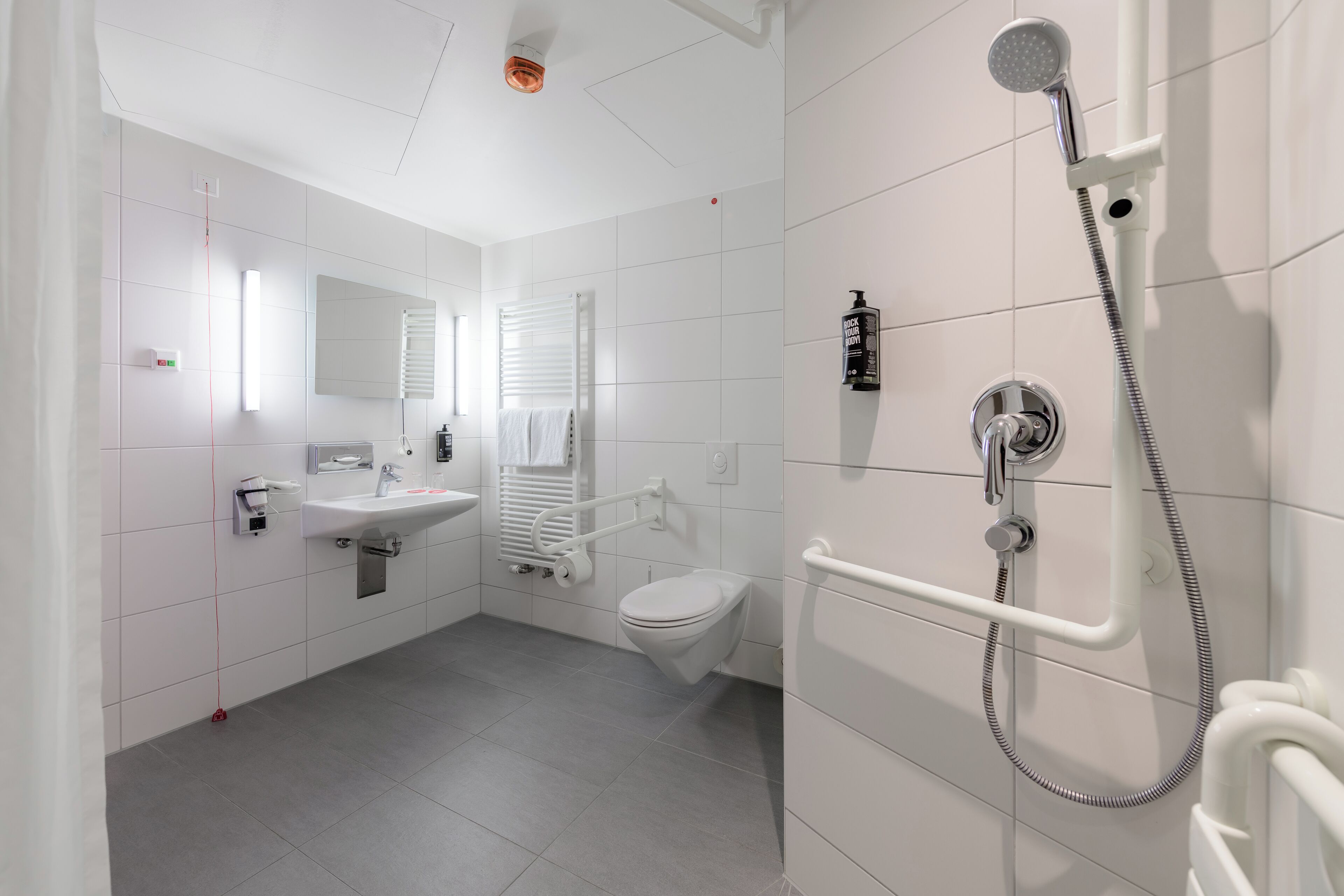 Un baño moderno con inodoro, lavamanos y ducha.
