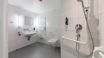 Un baño moderno con inodoro, lavamanos y ducha.