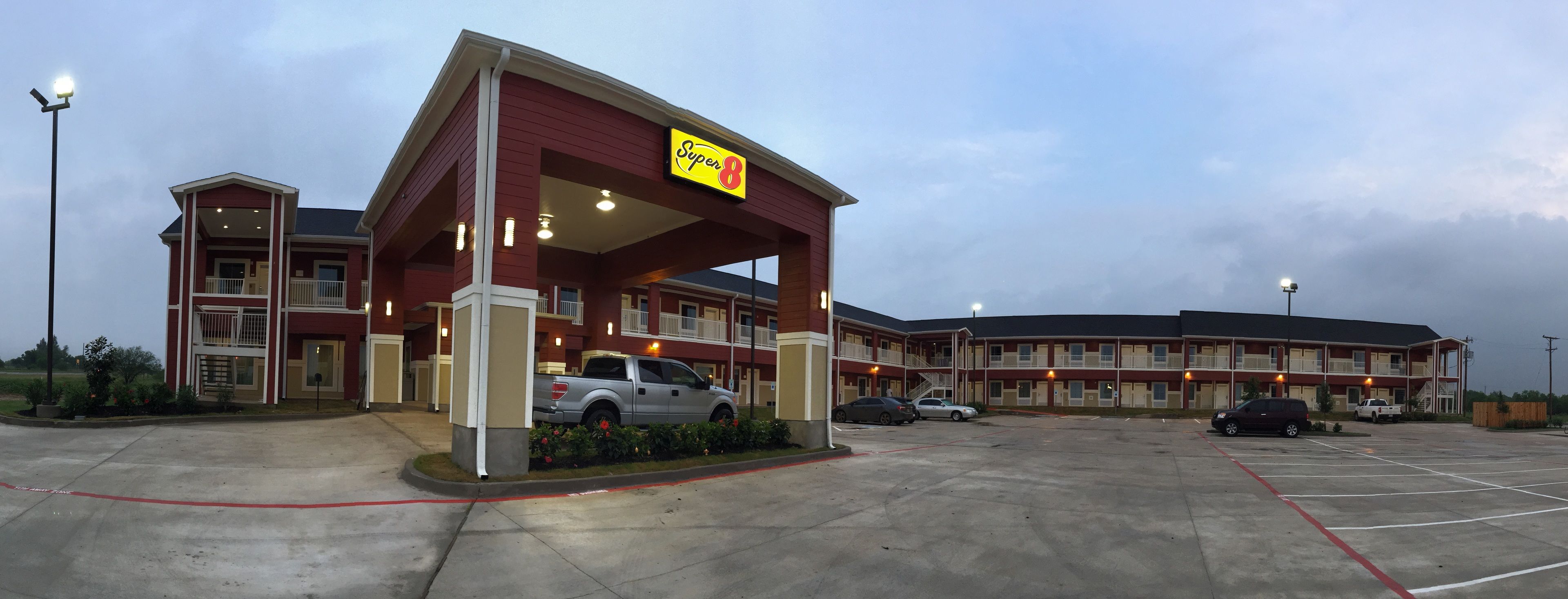 A Super 8 motel with a large parking lot and multiple buildings.
