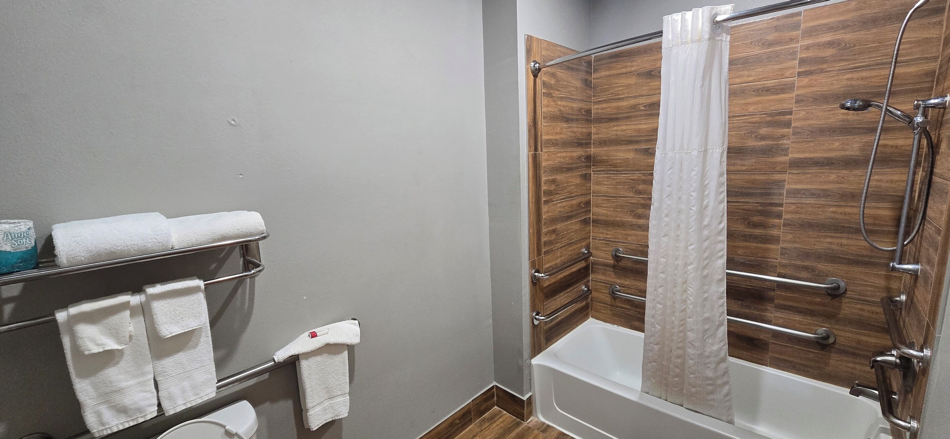 Une salle de bain équipée d’une douche, d’une baignoire et d’un porte-serviettes avec plusieurs serviettes.