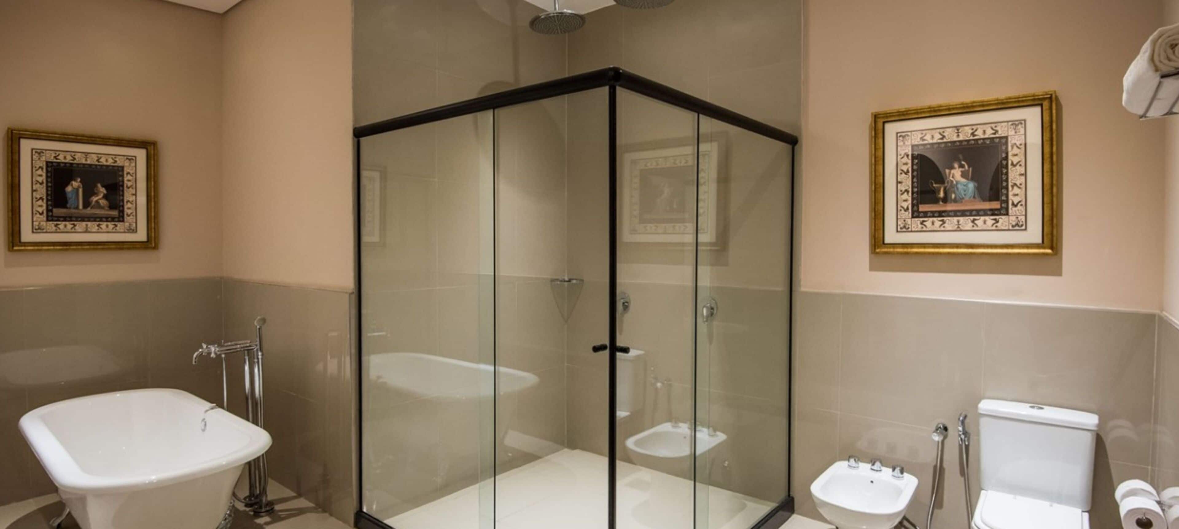A modern bathroom with a glass-enclosed shower, a freestanding bathtub, a toilet, and a sink.