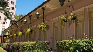 Un edificio con macetas colgantes y un jardín cuidado.