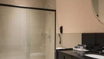 A modern bathroom with a glass-enclosed shower, a black sink, and a mirror above the sink.