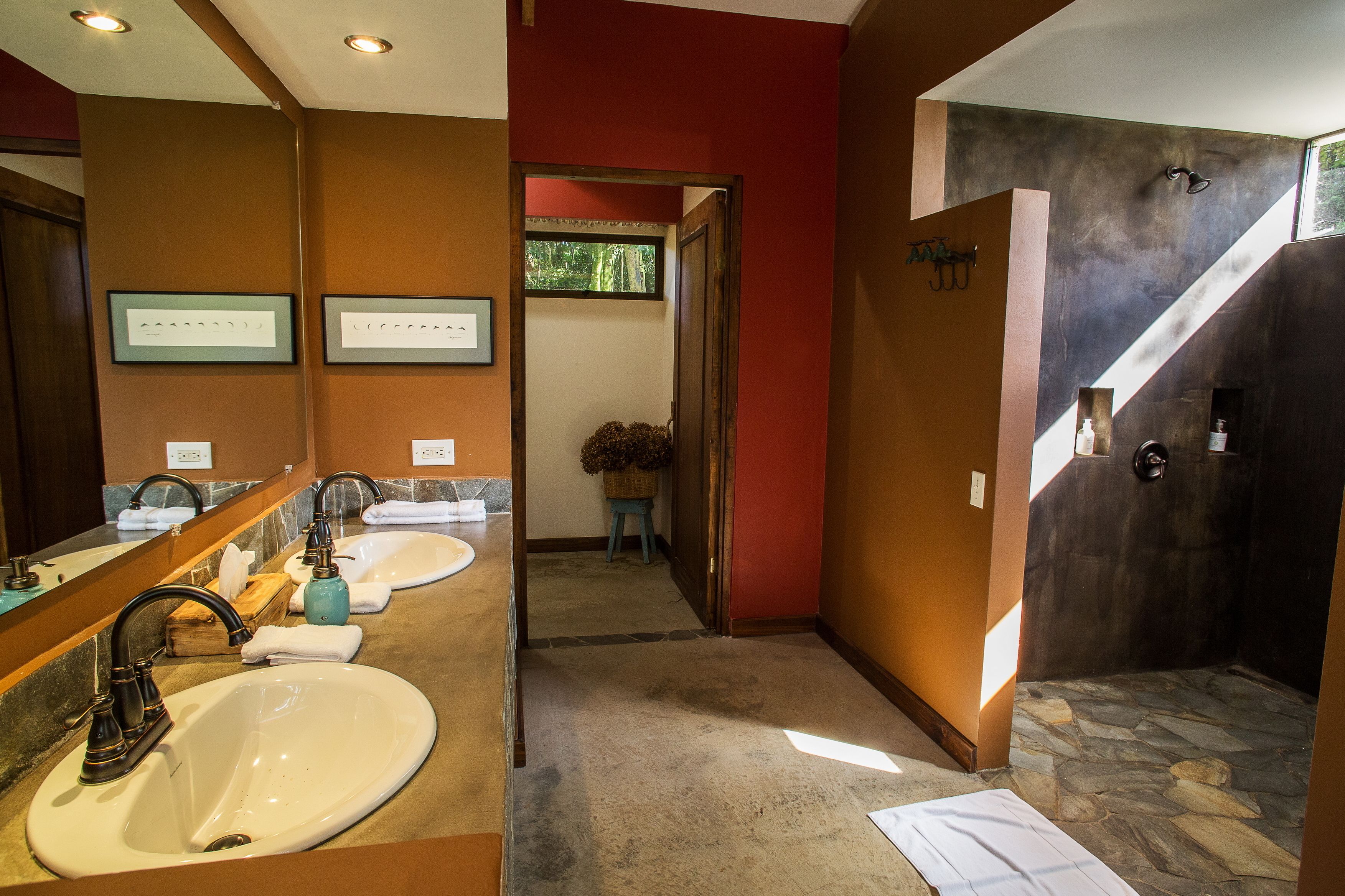 Un baño con dos lavamanos, un espejo y una zona de ducha.