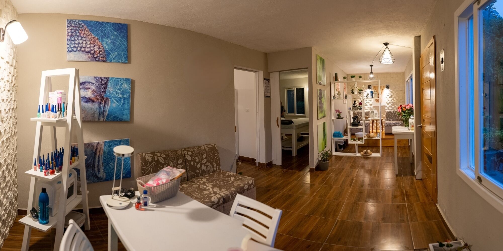 A spacious living area with a sofa, a dining table, and a kitchen in the background.