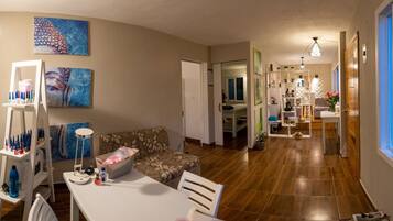 A spacious living area with a sofa, a dining table, and a kitchen in the background.