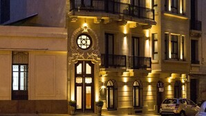 A multi-story building with a classic architectural style, featuring a prominent entrance with a decorative arch and a balcony. - Alma Histórica Boutique Hotel (Montevideo)