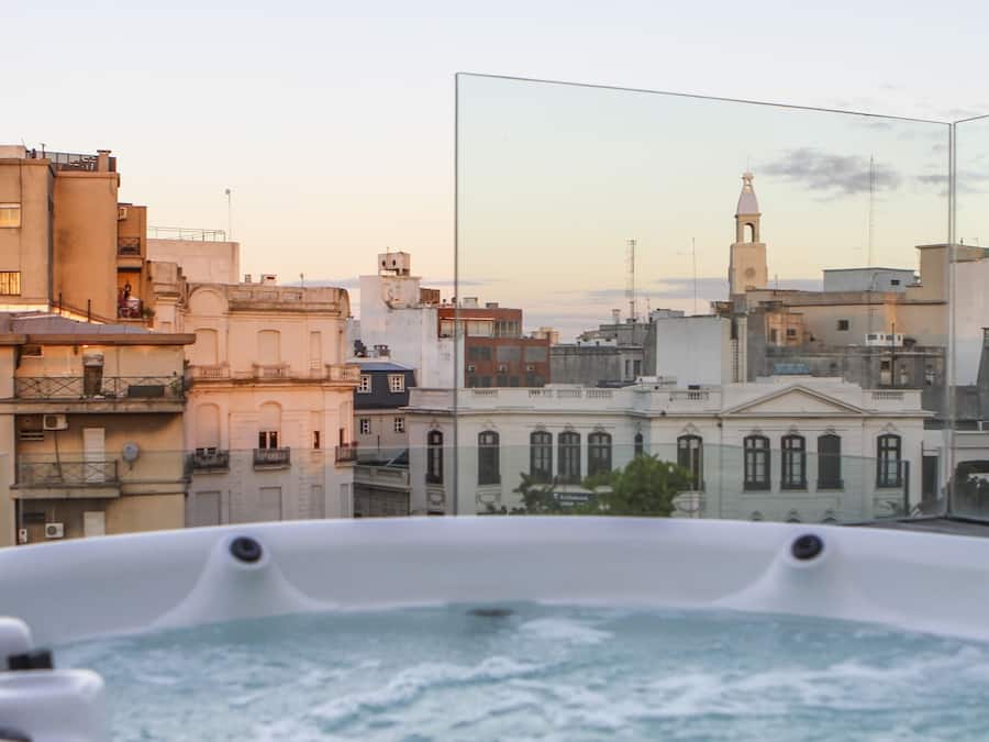 Un jacuzzi con vistas a la ciudad, incluyendo un edificio destacado con una torre de campanas.