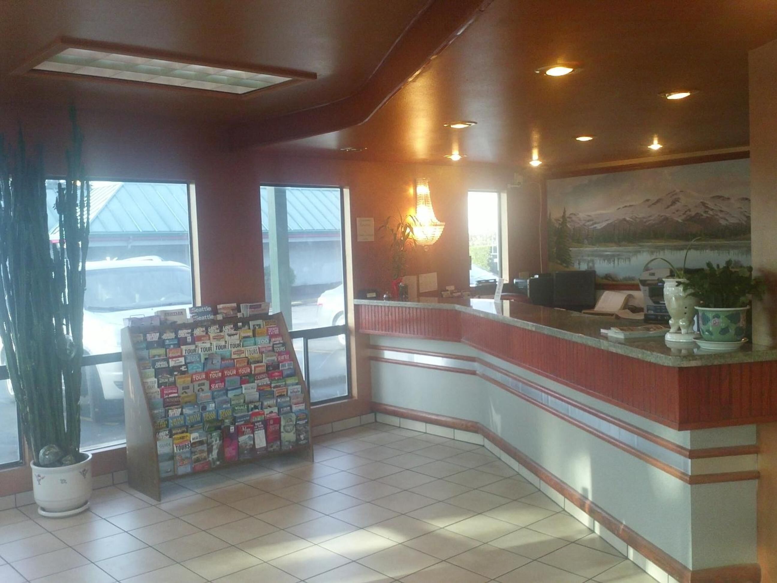A reception area with a counter, a large window, and a wall-mounted painting.