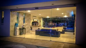 A modern interior with a seating area, a bar, and a view of the street outside. - Sara Suites Ixtapa (Ixtapa)