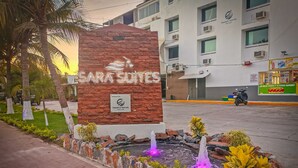 A hotel entrance with a sign reading "SARA SOUTHS" and a plaque indicating it's operated by "Trade & Travel." - Sara Suites Ixtapa (Ixtapa)